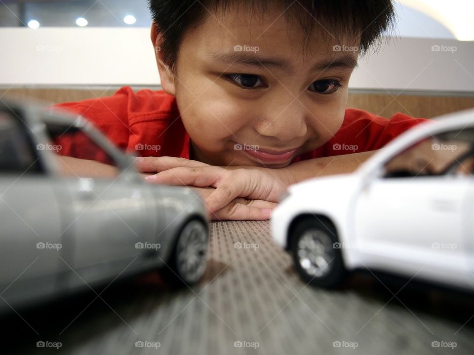 young boy playing with toy cars