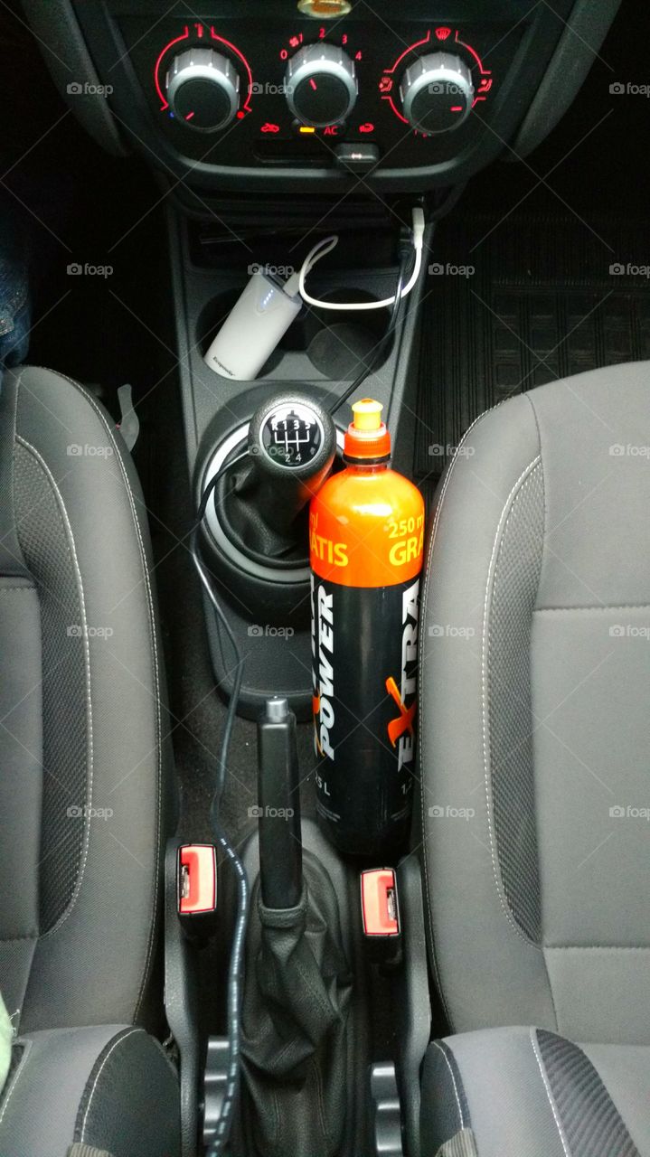 Câmbio, bancos, e painel do carro. Garrafa plastica com agua.