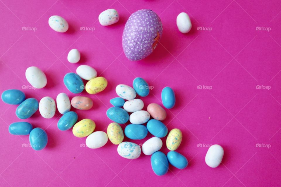 Candy Easter eggs on a bright pink background 
