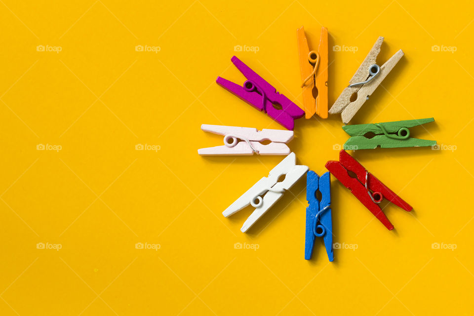 multicolored decorative clothespins , yellow background.  paint the world with colored paints !