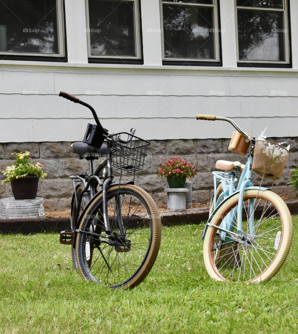 Two old Huffy bicycles sitting in front of the house