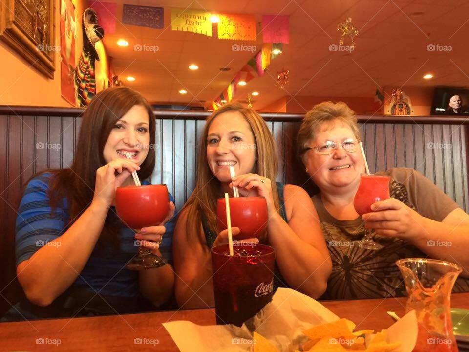 A mother and her two daughters celebrating, margarita style!