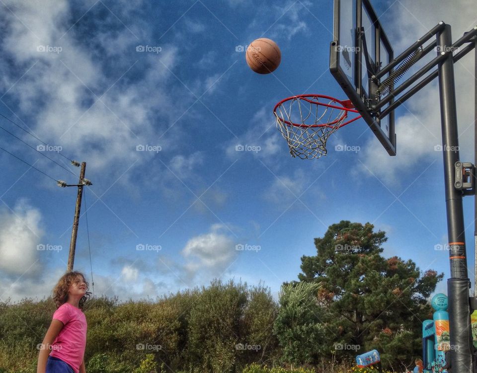 Young Girl Shooting Basketball Hoops