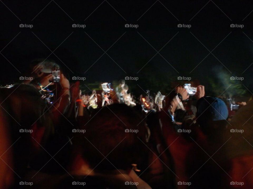 People taking pictures at a concert. 
