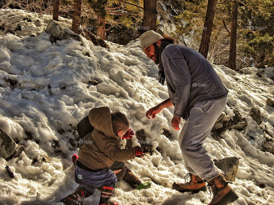 Father And Son Playing In The Snow
