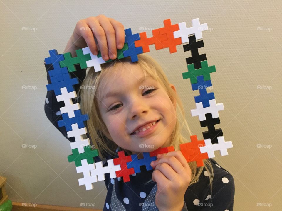 Young girl age of five playing with a frame on kindergarden.