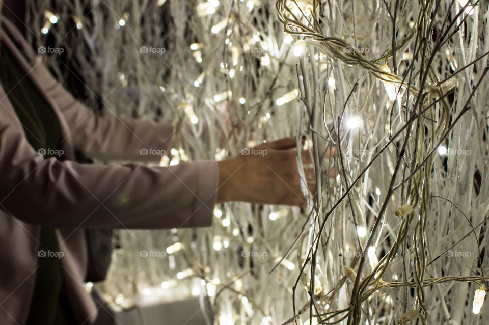 Woman arranging Christmas or New Years holiday lights for party 