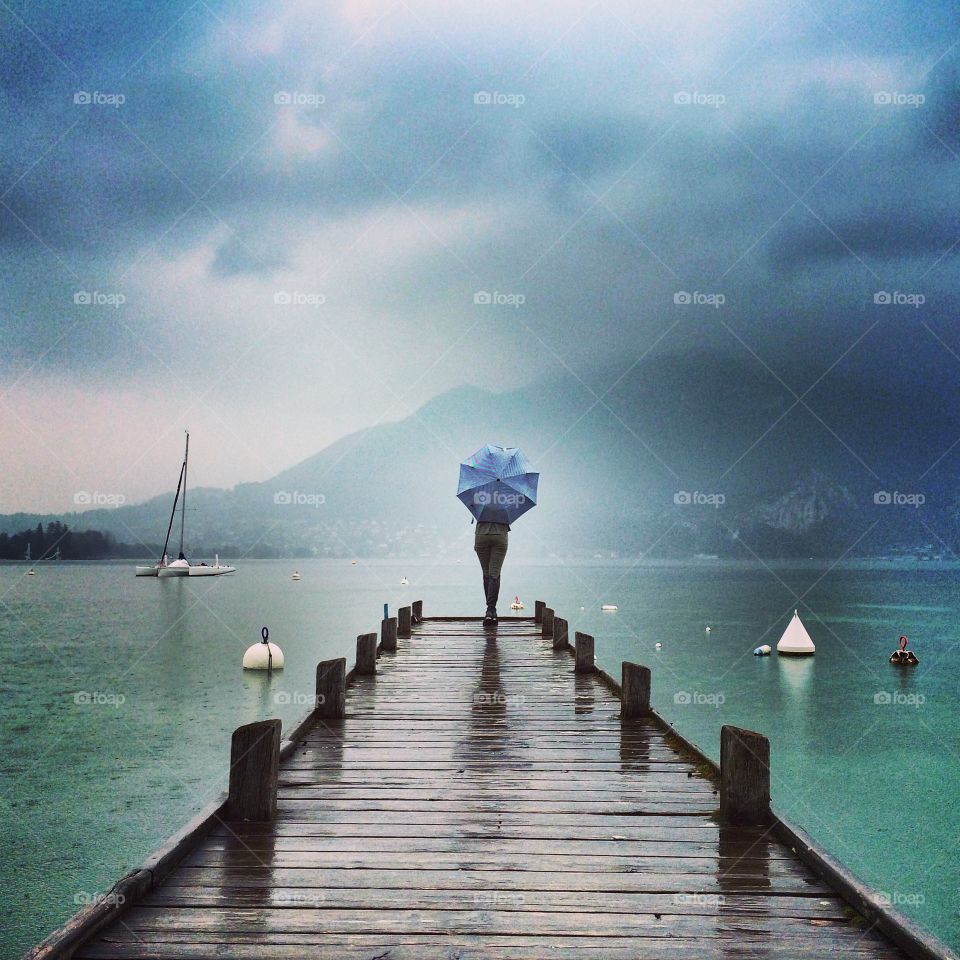 Rear view of a woman holding umbrella at annecy lake france