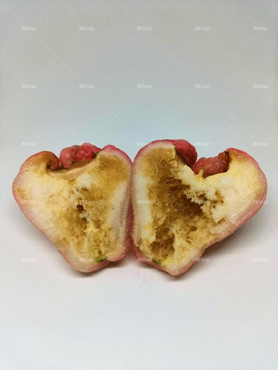 Close-up rotten and wormy of wax apple isolated on
white background. Selective focus, underexposed, blurry, low light, too
soft