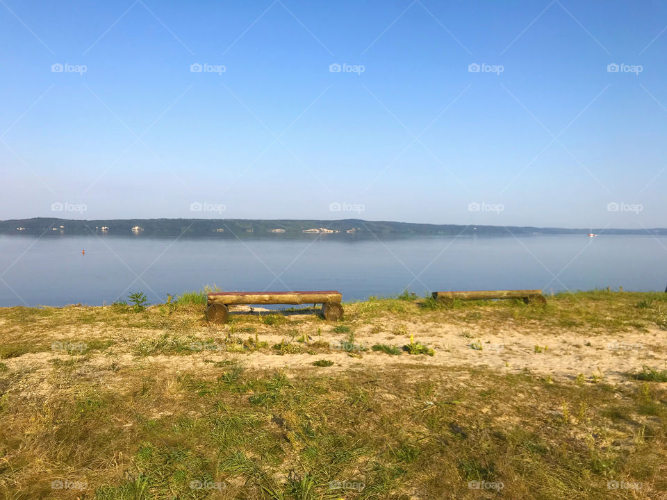 Wooden bench on the lake’s beach