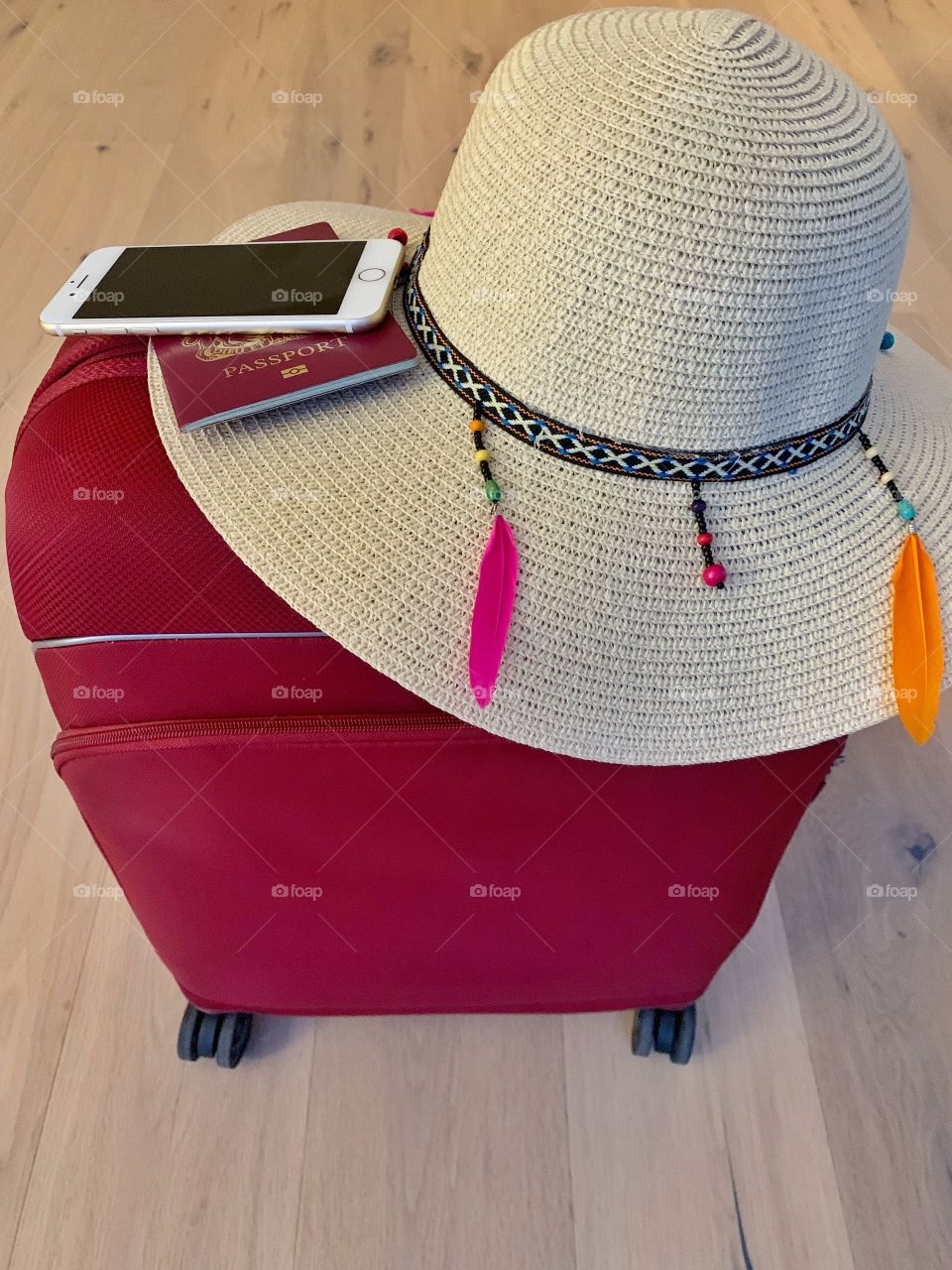 Suitcase with passport, phone and hat