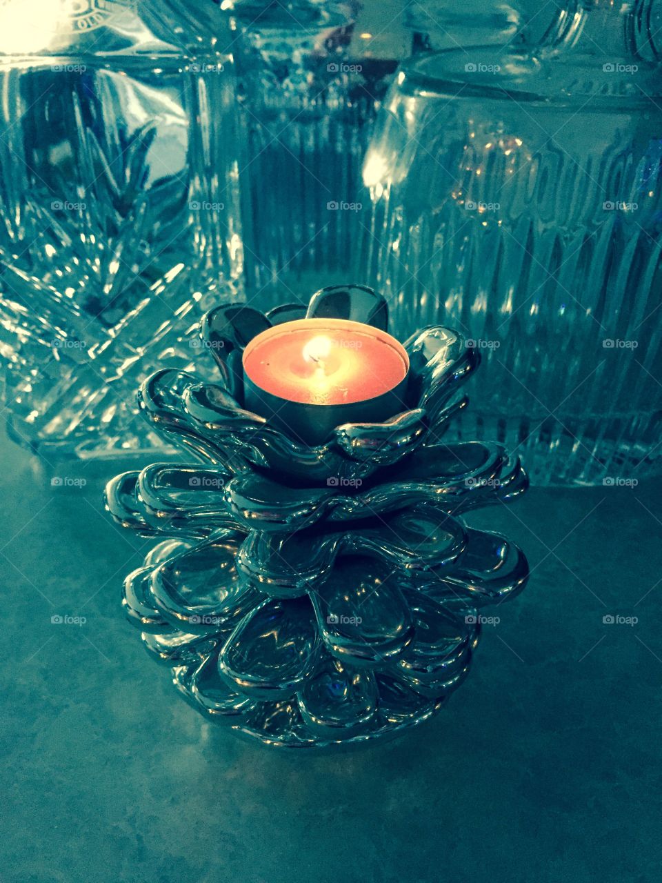 Silver pinecone . Silver candle holder with lighted candle