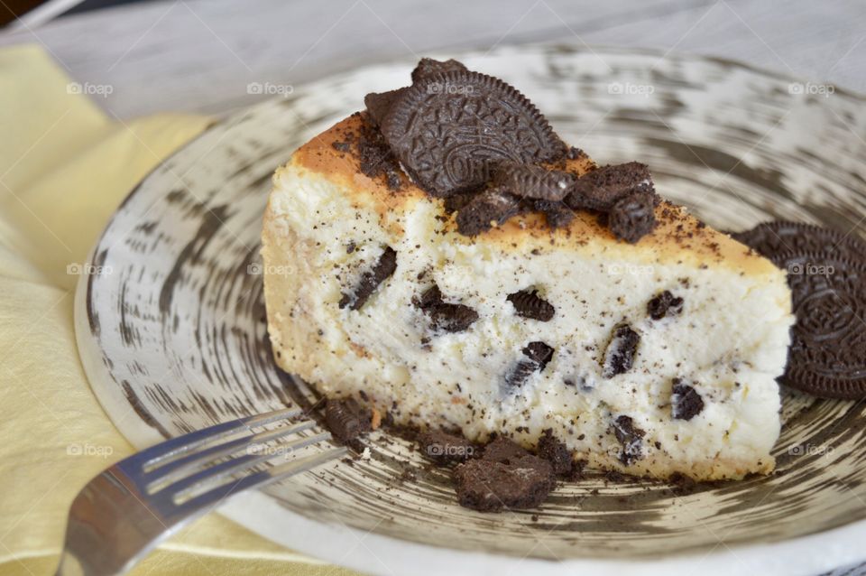 Oreo cookie cheesecake on a high contrasting plate with a fork