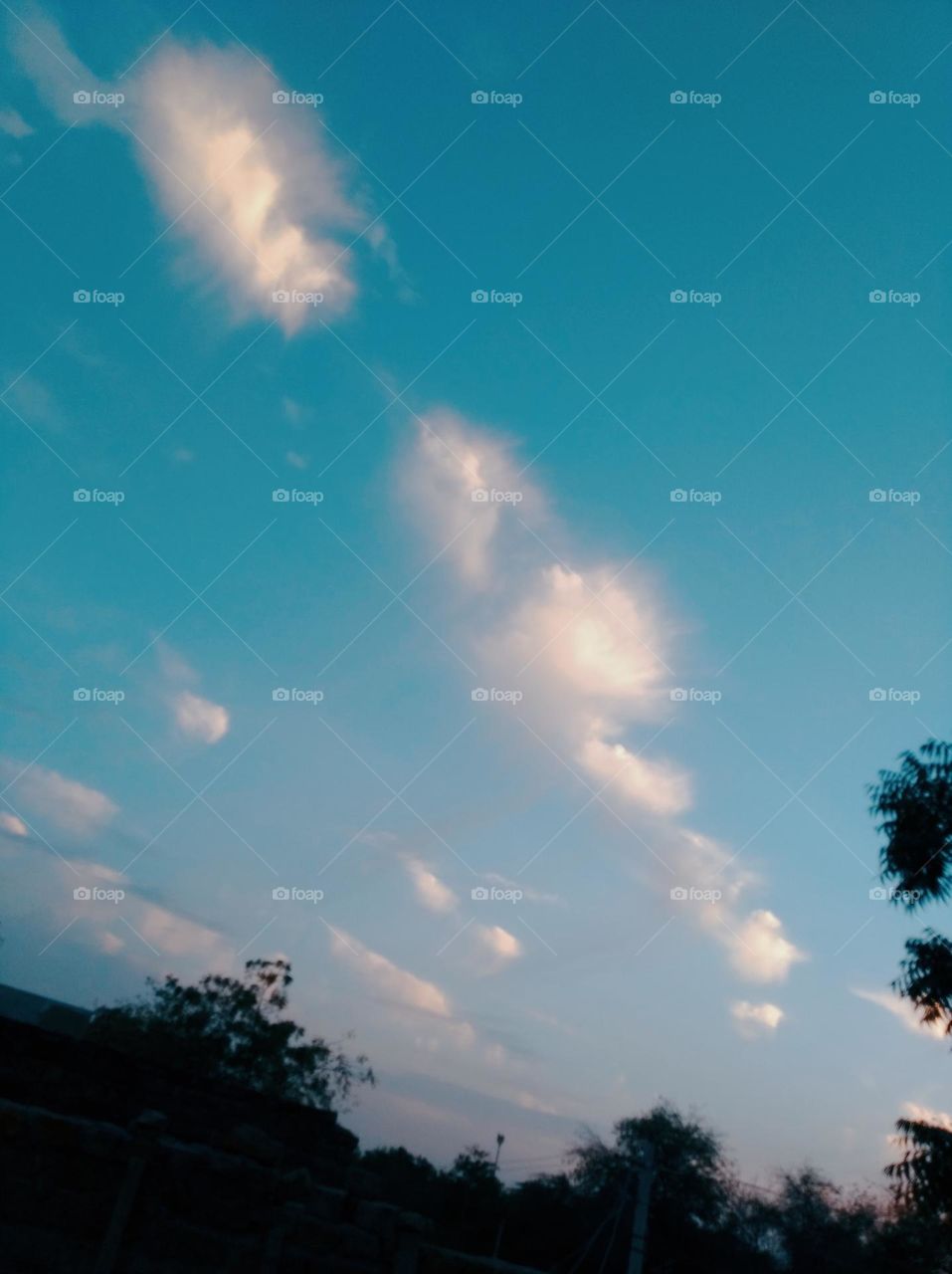 a dark blue sky, whitish cloud scattered, weather is good, green plant tree looks very beautiful