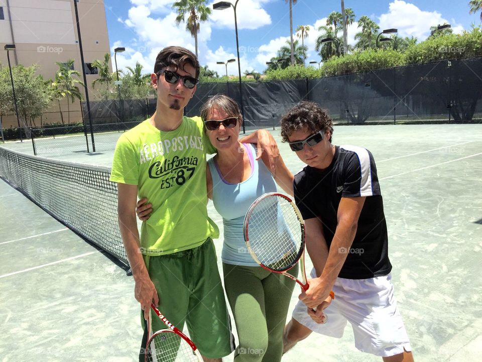 Tennis . Portrait of mother with two sons at tennis court, Weston, Florida, USA 