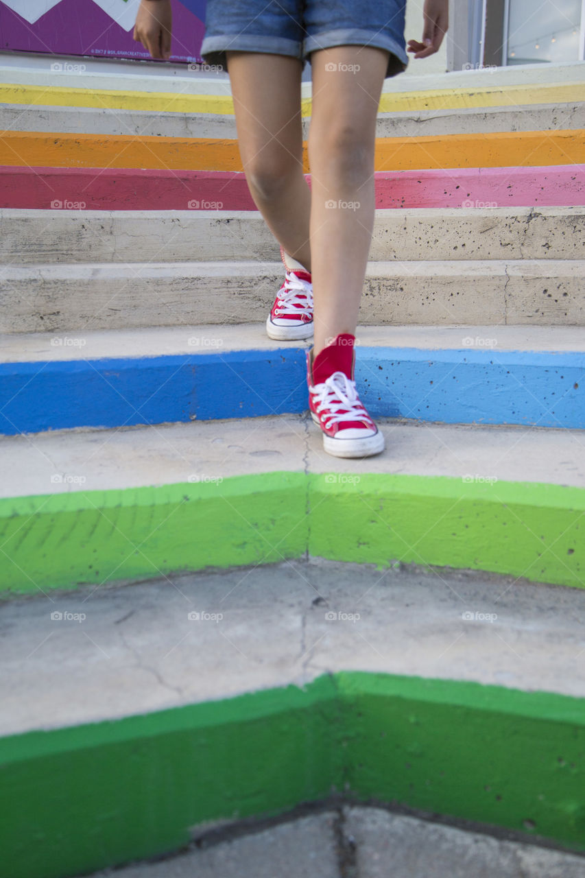 Girl walking down some colorful stairs 