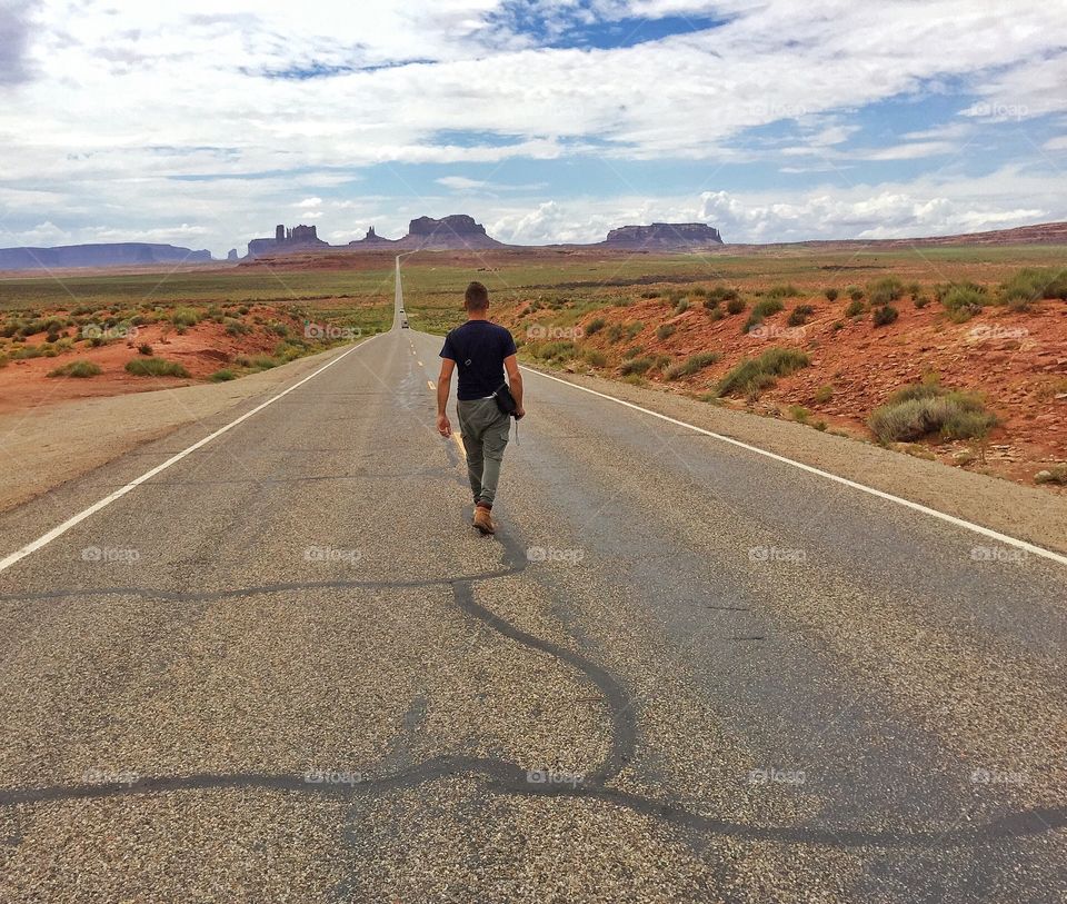 solitary man on I163 walking towards monument valley tribal park in Utah
