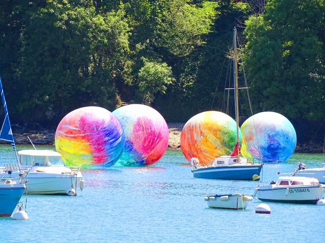 Huge colourful balls amongst sailing ships in Rosmeur port in Douarnenez
