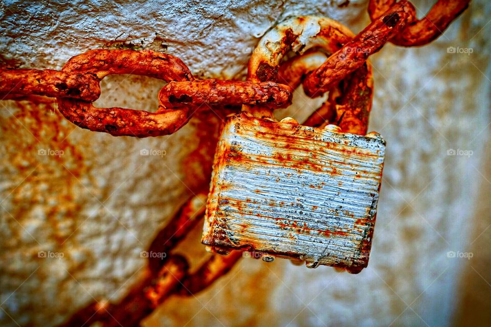 Rusted Lock Securing Chains To An Abandoned Warehouse