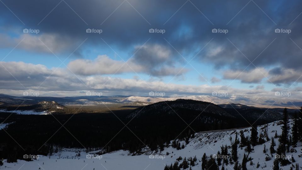 Snow in valley and hills. Cloud covering snowy mountains and valley