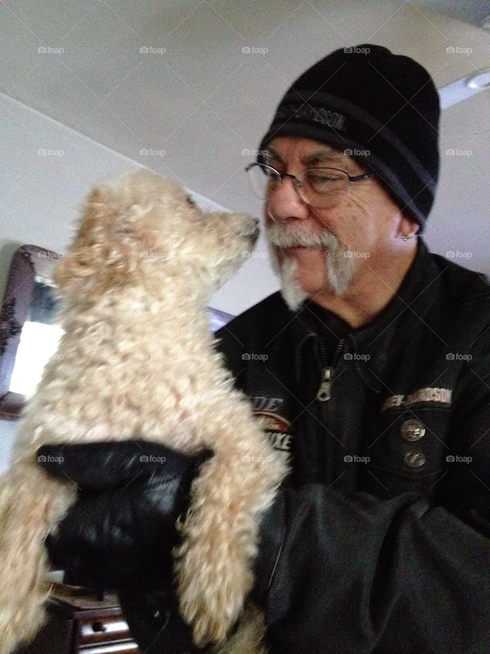 Man & white puppy nose to nose looking at each other. Trust, love.