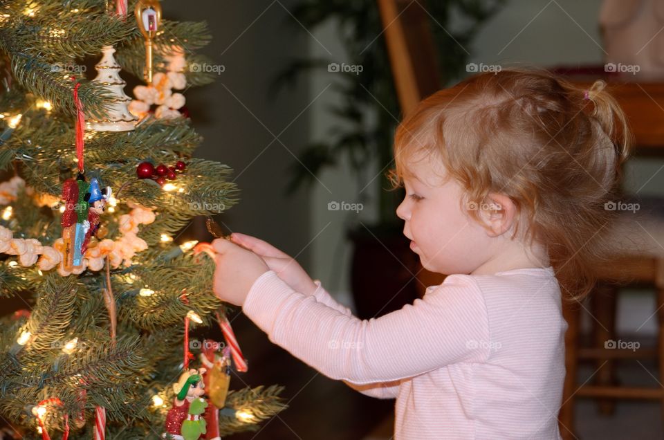 Little girl decorating christmas tree