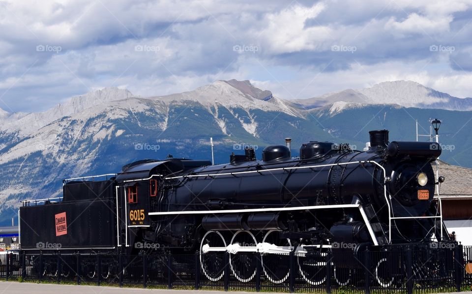Canadian train engine in Jasper with mountains in distance. 