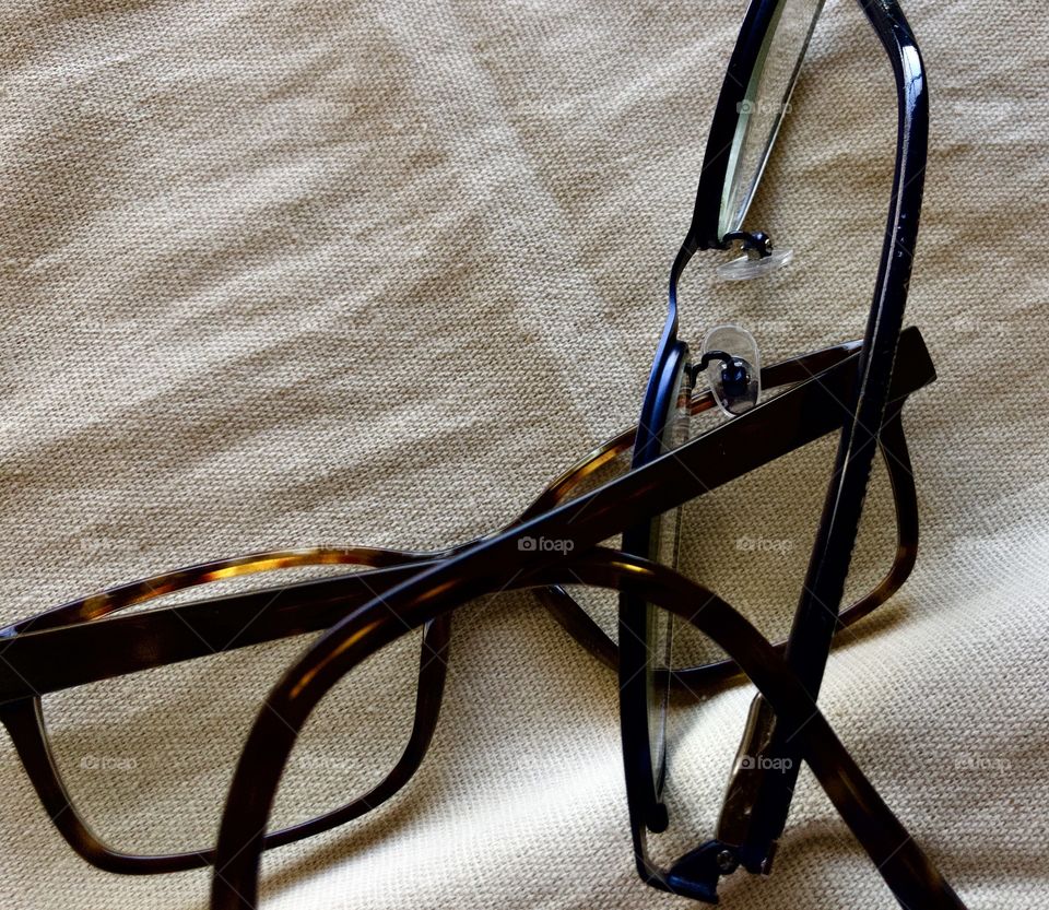 Two pairs of glasses on canvas fabric background 