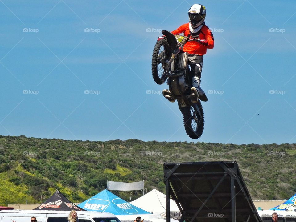Motorcycle Stunt. Expert Rider Jumping A Motorcycle Off A Ramp
