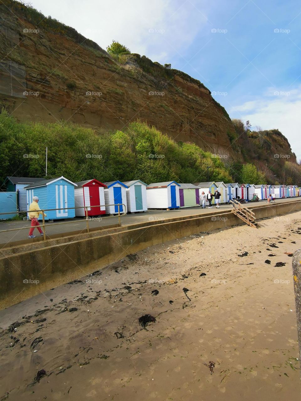 The first sunny spring days in England. Sea shore. Bright beach houses are waiting for vacationers. April. Beach. The beach season will start soon.