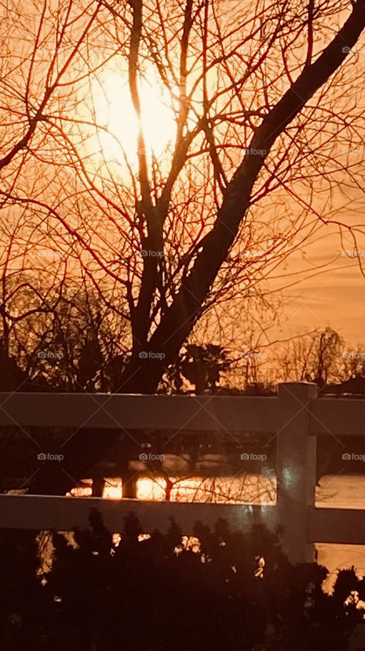 Evening Sunset high clouds spreading the sunbeams with the clouds. Evening colors appear strong for this early pic. Reflections of the Sunbeams / Rays off the lake waters.