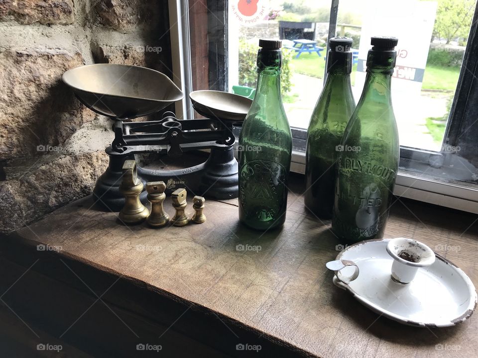 Weighing scales are a forgotten treasure and they blend neatly with some coloured bottles.