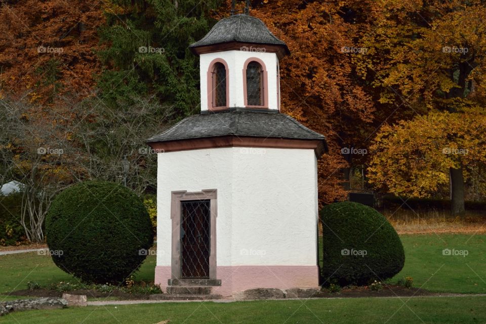Villingen park. Outdoor shot of a tiny white chapel with golden and red autumn trees in the back.