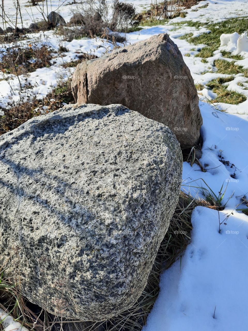 thaw in February - remains of snow and snow free rock on the garden