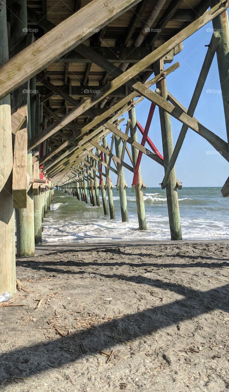 A picture from under the pier at Folly Beach, South Carolina at high tide