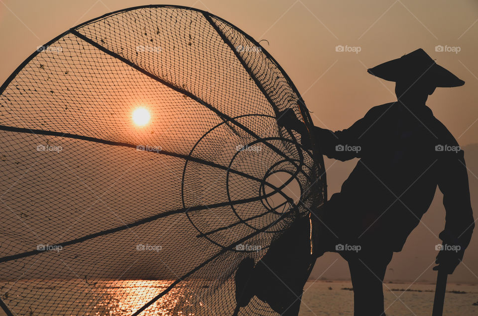 Traditional Burmese fisherman at sunrise on Inle lake