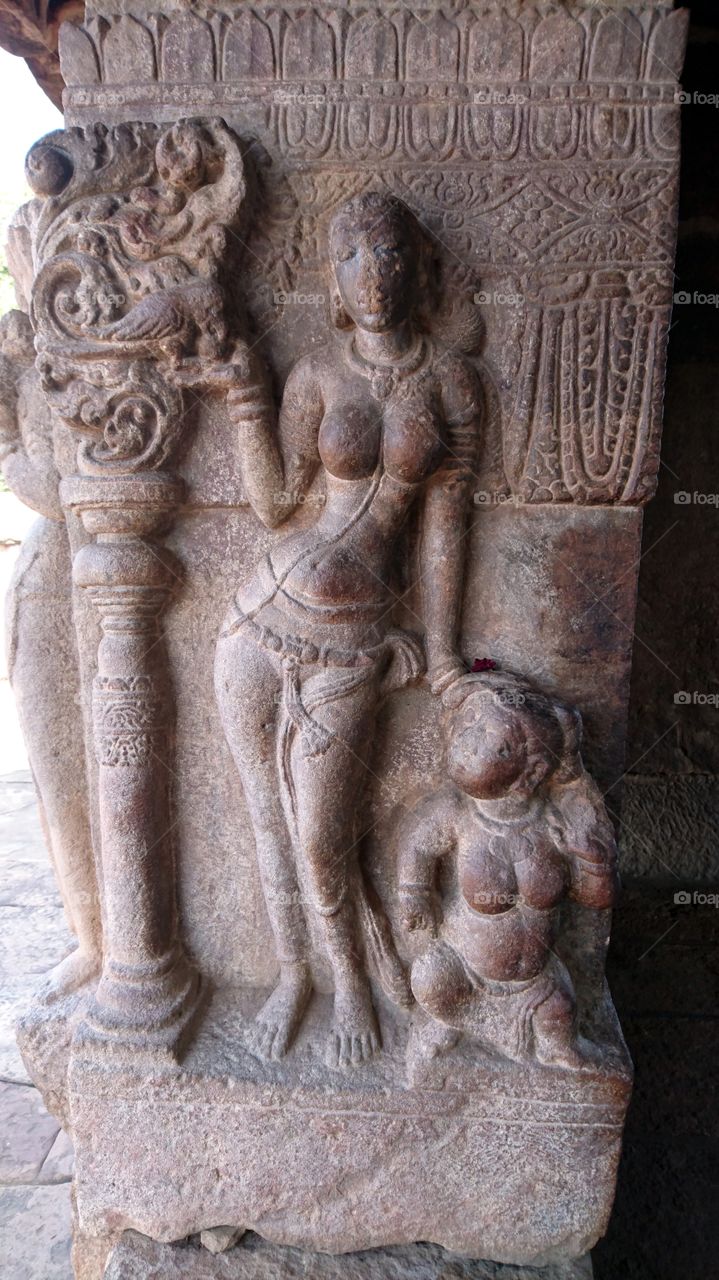 Pattadakal : Young lady feeding parrot and teaching her cousin / a child about caring all other living organisms