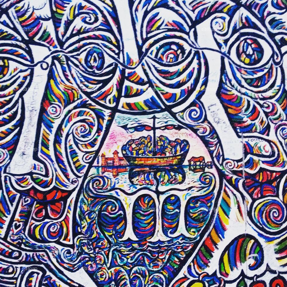 Graffiti of abstract faces and people on a boat, from the East Side Gallery in Berlin