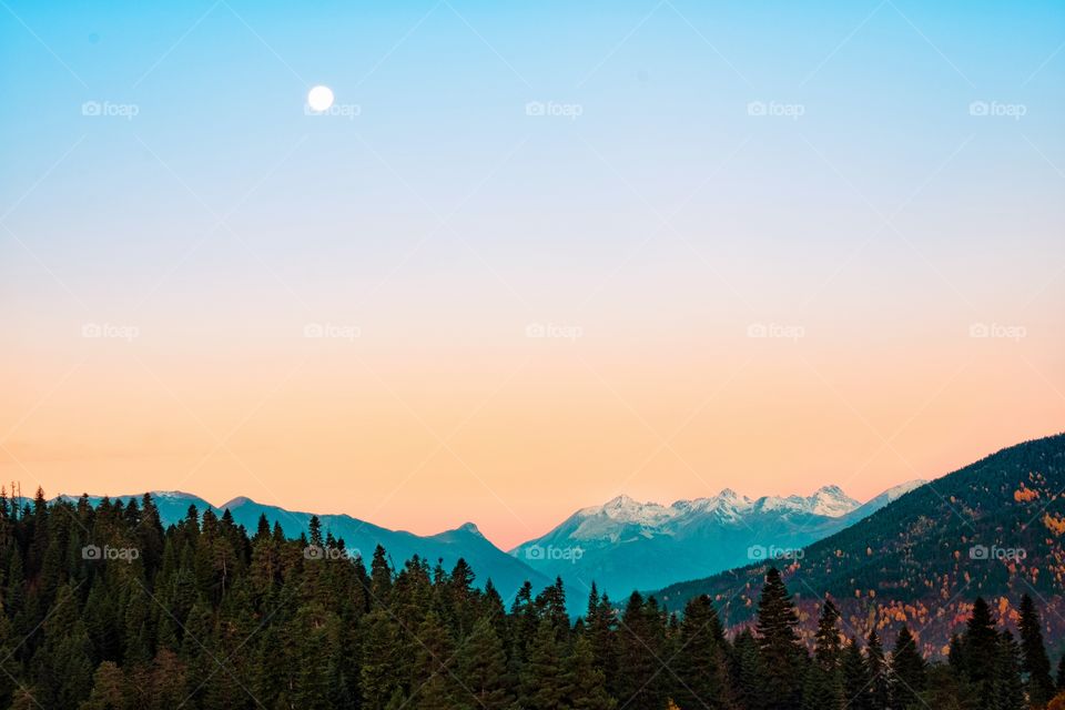 Moon in morning twilight over beautiful mountain scape at Georgia countryside 