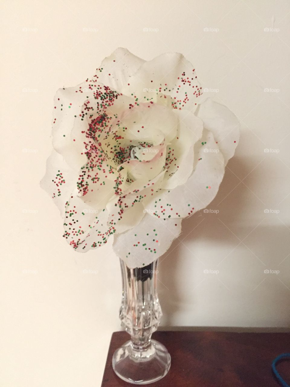 White rose with glitter in a glass vase