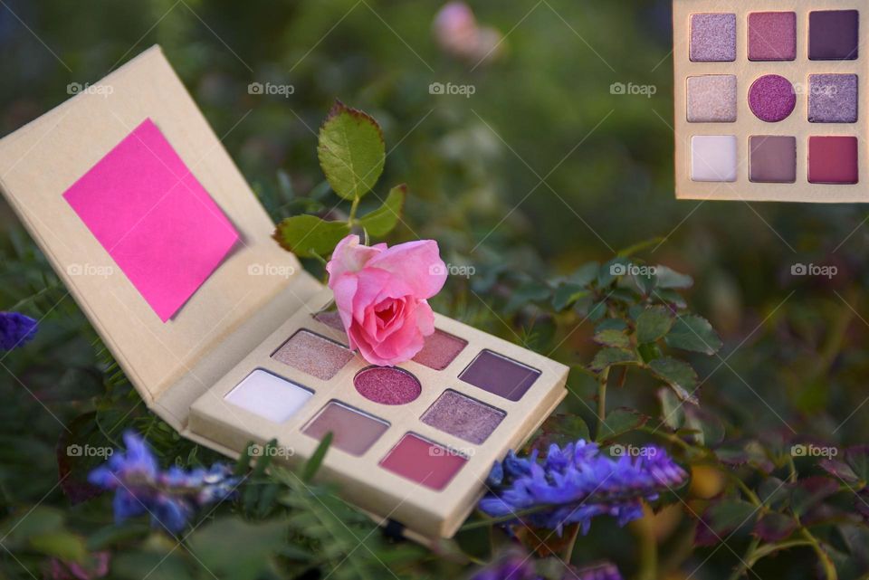 Eye shadow palette on floral background.