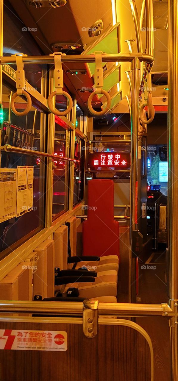 A retro-style bus with a warm yellow light interior. The marquee reads "Please pay attention to safety while driving" in Chinese