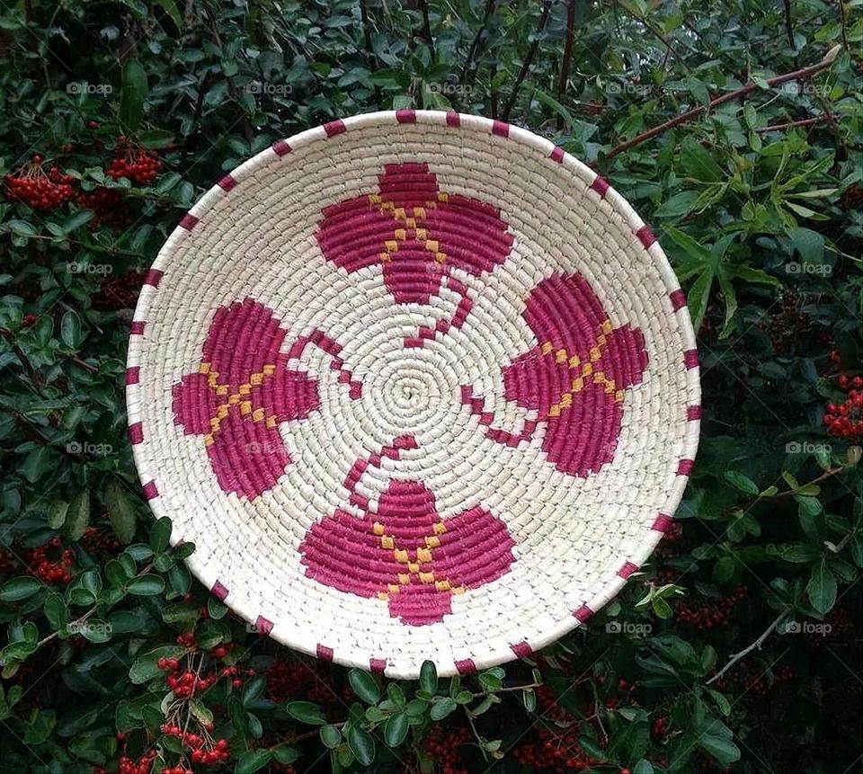 The image shows a group of hand -made dishes of wicker, decorated with colored embroideries with beautiful floral shapes, and is elegantly displayed in a warm corner that combines heritage and beauty, which gives the place an artistic spirit and attr