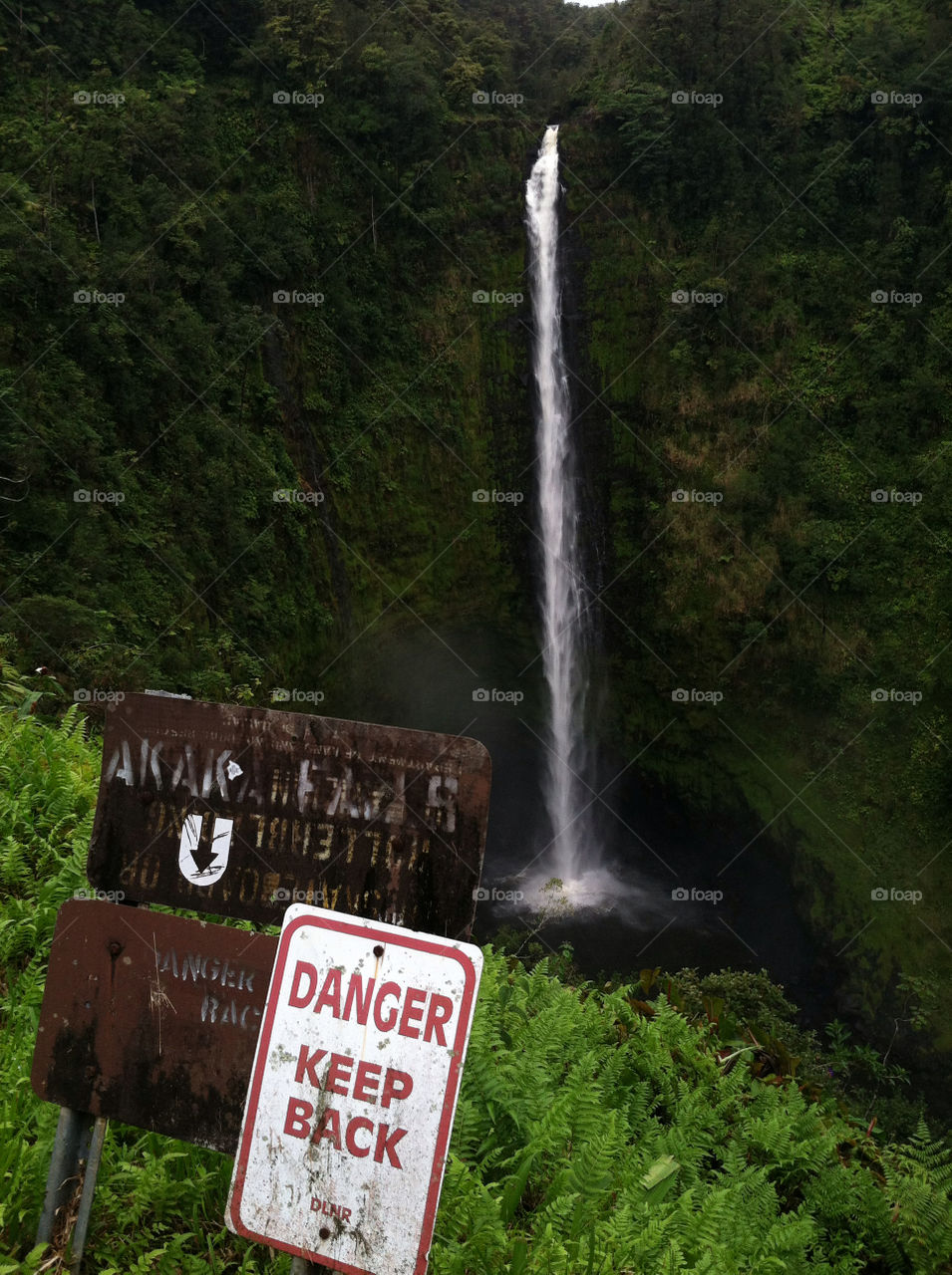 Warning sign board near waterfall