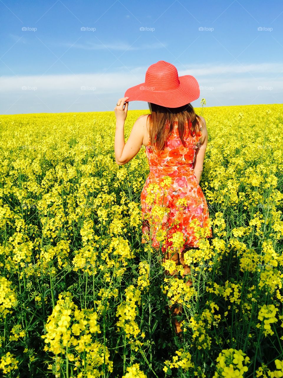 Rear view of a woman in rapeseed field