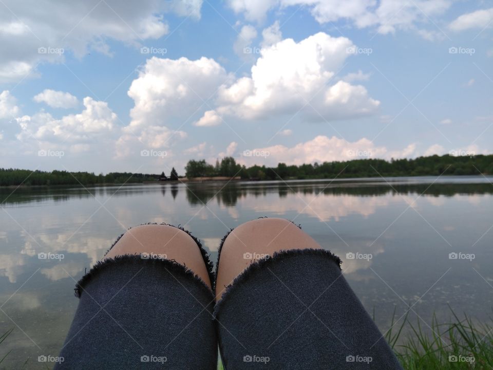 female legs resting on a lake summer landscape