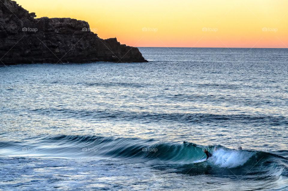 A man surfing on sunset 