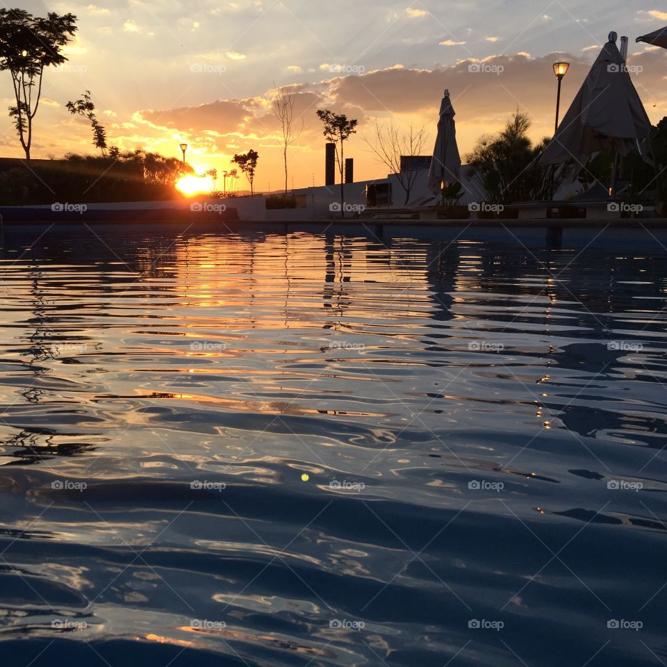 A beauty sunset behind silhouette water pool