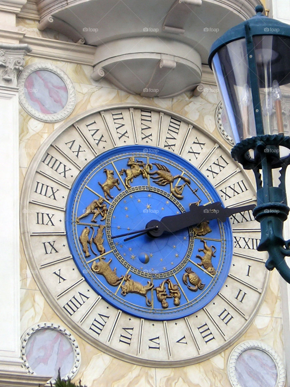 A Dramatic and fancy clock with zodiac signs and Roman numericals.