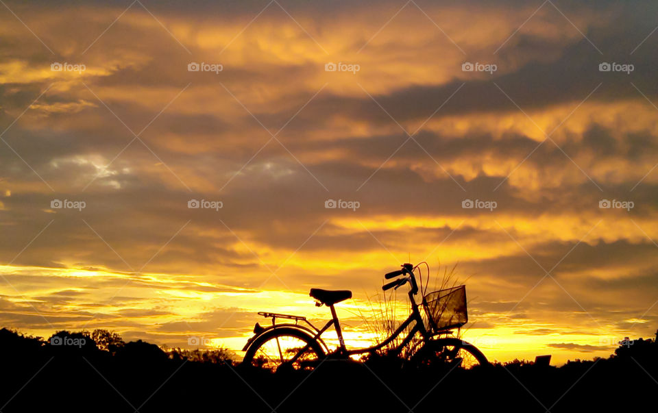 Bicycle parked with sunset at the background